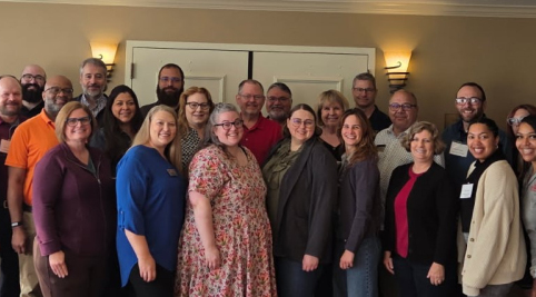 a large group of people standing in front of a wall